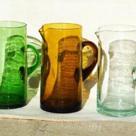 Handmade Moroccan recycled glass pitcher in green, amber, and clear colors crafted by local artisans
